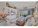 Bright living room with a ceiling fan, neutral walls, built-in shelving, and patio access at 8320 Creekview Ln, Englewood, FL 34224