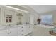 Bright main bathroom with dual sinks, large mirrors and separate bathtub at 8320 Creekview Ln, Englewood, FL 34224