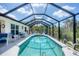 Relax in this screened pool oasis featuring a spacious deck, comfortable seating, and serene views at 8320 Creekview Ln, Englewood, FL 34224