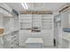 Spacious walk-in closet featuring custom shelving and drawers for optimal storage at 8320 Creekview Ln, Englewood, FL 34224