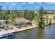 Aerial view capturing the home's waterfront location, pool, dock, and lush landscaping, showcasing outdoor living at 8400 Antwerp Cir, Port Charlotte, FL 33981