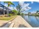 Paver patio leading to a dock along the waterfront with lush landscaping at 8400 Antwerp Cir, Port Charlotte, FL 33981