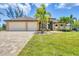 Charming home featuring a spacious three-car garage, lush landscaping, and manicured lawn at 8400 Antwerp Cir, Port Charlotte, FL 33981