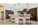 Modern kitchen featuring a large center island with granite countertops, dark wood cabinets, and pendant lighting at 8400 Antwerp Cir, Port Charlotte, FL 33981