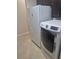 Bright laundry room with tile floors and a side-by-side washer and dryer, plus a refrigerator for convenience at 8400 Antwerp Cir, Port Charlotte, FL 33981