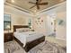 Main bedroom with tray ceiling, ceiling fan, art, and view of en-suite bathroom at 8400 Antwerp Cir, Port Charlotte, FL 33981