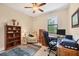 Well-lit home office has a comfortable recliner, ceiling fan, and functional workspace at 8400 Antwerp Cir, Port Charlotte, FL 33981