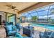Screened-in patio with cozy seating area overlooking pool and canal at 8400 Antwerp Cir, Port Charlotte, FL 33981