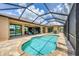 Lovely outdoor pool with a screen and adjacent brick patio and chairs and open access to the house at 8400 Antwerp Cir, Port Charlotte, FL 33981