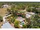 Aerial view of the home surrounded by trees, featuring a pool, and landscaped yard at 875 Morrison Ave, Englewood, FL 34223