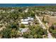 Breathtaking aerial view of a serene property showcasing a home and pool nestled within lush greenery near a stunning bay at 875 Morrison Ave, Englewood, FL 34223
