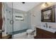 The bright bathroom showcases a modern vanity, mirror, and a tiled shower at 875 Morrison Ave, Englewood, FL 34223