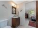 Bathroom featuring a modern vanity, decorative mirror, and adjacent bedroom view at 875 Morrison Ave, Englewood, FL 34223