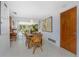 Cozy dining room featuring a rustic wooden table, wicker chairs, and access to the outdoor patio at 875 Morrison Ave, Englewood, FL 34223