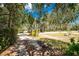 Long driveway framed by mature trees and lush greenery provides shade and privacy at 875 Morrison Ave, Englewood, FL 34223