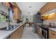 Functional kitchen with wooden cabinetry and modern appliances opening to the dining area at 875 Morrison Ave, Englewood, FL 34223