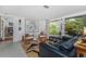 Bright and airy living room with terrazzo floors, a large abstract painting, and natural light from large windows at 875 Morrison Ave, Englewood, FL 34223