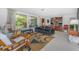 Well-lit living room with terrazzo floors, large windows, stylish seating, and a built-in bookshelf at 875 Morrison Ave, Englewood, FL 34223
