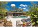 Inviting kidney-shaped pool and brick patio, screened in porch, with lush landscaping creates a private backyard oasis at 875 Morrison Ave, Englewood, FL 34223