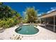 Lush backyard featuring a kidney-shaped pool, tropical landscaping, and brick paver patio at 875 Morrison Ave, Englewood, FL 34223