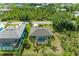 Aerial view showcases a private backyard oasis with a screened pool and lush tropical landscaping at 9211 Koma St, Port Charlotte, FL 33981