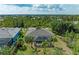Aerial view of the property showing a private pool with screen, palm trees, and landscaping at 9211 Koma St, Port Charlotte, FL 33981