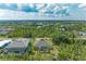 An aerial view shows a screened in pool and lush landscaping at 9211 Koma St, Port Charlotte, FL 33981