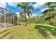 Beautiful backyard with manicured lawn and screened-in pool at 9211 Koma St, Port Charlotte, FL 33981