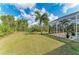 Expansive backyard featuring manicured lawn and screened in pool at 9211 Koma St, Port Charlotte, FL 33981