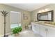 Stylish bathroom with double sinks, granite countertops, a large window, and a plant at 9211 Koma St, Port Charlotte, FL 33981