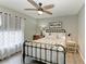 Stylish bedroom featuring neutral walls and carpet, a decorative ceiling fan, and window at 9211 Koma St, Port Charlotte, FL 33981