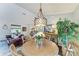 Cozy dining area with a round wooden table, decorative chandelier, and bright plant creates a welcoming and charming atmosphere at 9211 Koma St, Port Charlotte, FL 33981