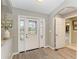 Bright foyer with a decorative glass door, wood-look floors, and an arched entryway at 9211 Koma St, Port Charlotte, FL 33981