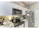 This kitchen features stainless steel appliances and abundant white cabinetry to offer a clean, modern space for cooking and storage at 9211 Koma St, Port Charlotte, FL 33981
