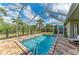Screened-in pool with brick patio and view of backyard at 9211 Koma St, Port Charlotte, FL 33981