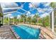 Screened-in pool with brick patio and view of the yard at 9211 Koma St, Port Charlotte, FL 33981