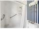 Shower with tile and accents, a handheld shower head, and white and blue striped walls at 1 Curacao Cir # 44, Englewood, FL 34223