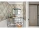 Elegant bathroom displaying an ornate vanity, decorative wallpaper and a glass door shower at 1 Curacao Cir # 44, Englewood, FL 34223