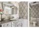Elegant bathroom featuring stylish wallpaper, a vessel sink, and a framed mirror at 1 Curacao Cir # 44, Englewood, FL 34223