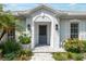 Inviting front entrance featuring a gray front door, decorative sconces, and lush landscaping at 1 Curacao Cir # 44, Englewood, FL 34223