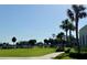 Scenic golf course view featuring lush landscaping, mature trees, and a winding path on a sunny day at 1 Curacao Cir # 44, Englewood, FL 34223