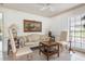 Cozy living room featuring neutral decor, a ceiling fan, and a bright window at 1 Curacao Cir # 44, Englewood, FL 34223