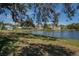 Scenic view of tranquil pond with several homes along the water's edge, shaded by a large tree at 1 Curacao Cir # 44, Englewood, FL 34223