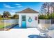Charming pool house with bright blue door and life preserver, on a sunny day near the lake at 1 Curacao Cir # 44, Englewood, FL 34223