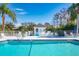 Community pool area with a bathhouse, white fencing, and ample seating for residents at 1 Curacao Cir # 44, Englewood, FL 34223