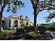Exterior view of the tennis center building featuring manicured landscaping and a clear blue sky at 1 Curacao Cir # 44, Englewood, FL 34223