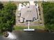 Aerial view of a home with a waterfront, featuring a dock, lanai, lush landscaping, and a driveway with ample parking at 10064 Cocoa Beach St, Port Charlotte, FL 33981