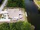 Aerial view of a waterfront property featuring a private dock, lanai, lush landscaping, and a driveway with ample parking at 10064 Cocoa Beach St, Port Charlotte, FL 33981