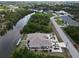 Aerial view of a waterfront home with a private dock on a canal, complemented by lush green landscaping and well-maintained grounds at 10064 Cocoa Beach St, Port Charlotte, FL 33981