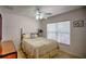 Bedroom features a ceiling fan, neutral walls, tile flooring, and a window at 10064 Cocoa Beach St, Port Charlotte, FL 33981